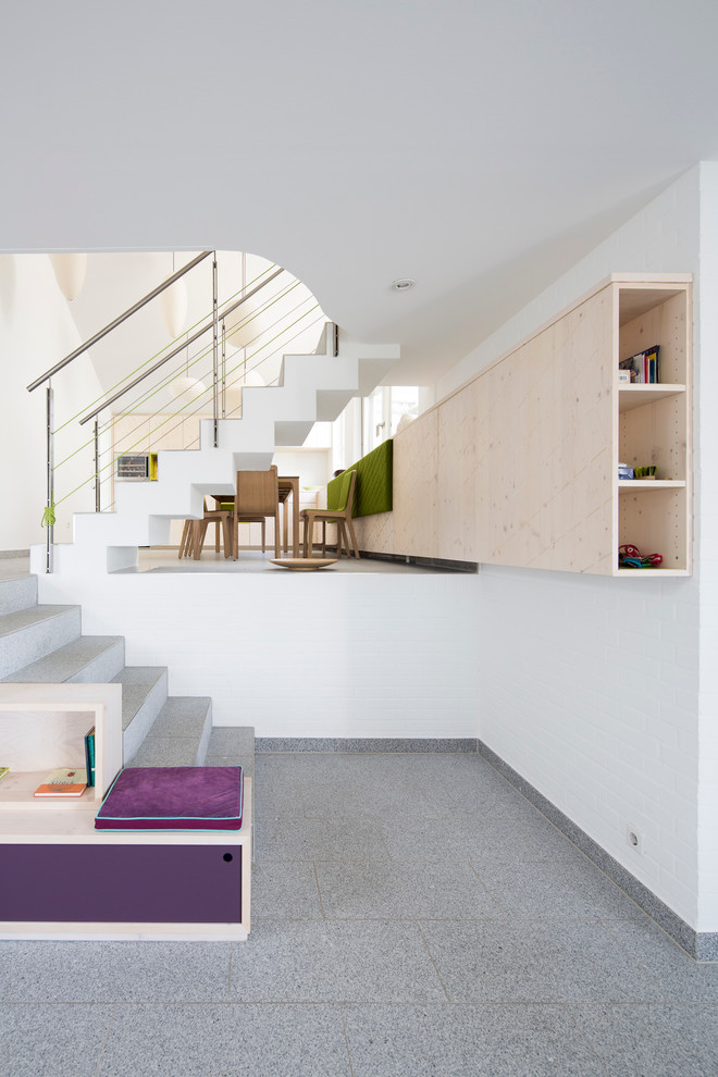 Inspiration for a large contemporary tiled u-shaped staircase in Stuttgart with tiled risers and under stair storage.