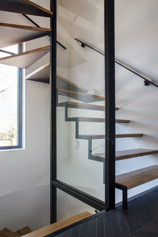 Diseño de escalera curva minimalista sin contrahuella con escalones de madera y barandilla de varios materiales