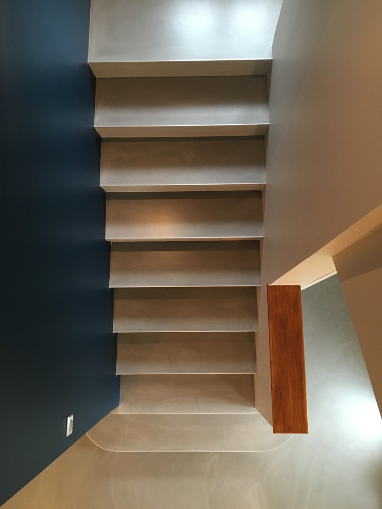 Exemple d'un escalier droit chic en béton de taille moyenne avec des contremarches en béton et un garde-corps en bois.