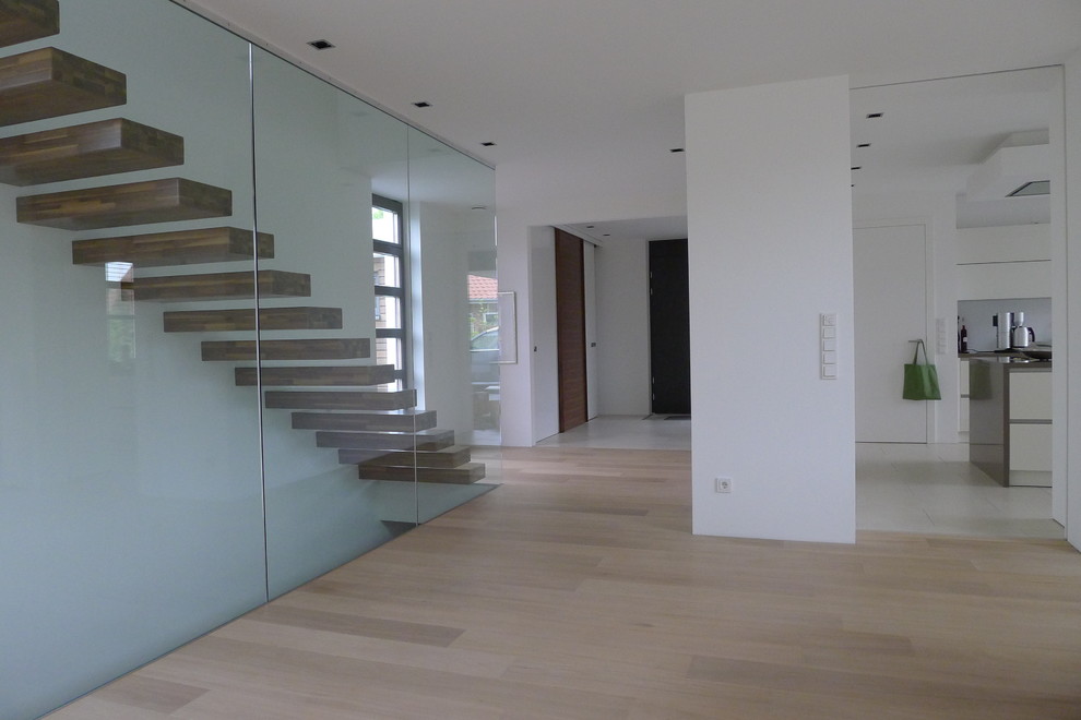 Idée de décoration pour un escalier flottant minimaliste avec des marches en bois.