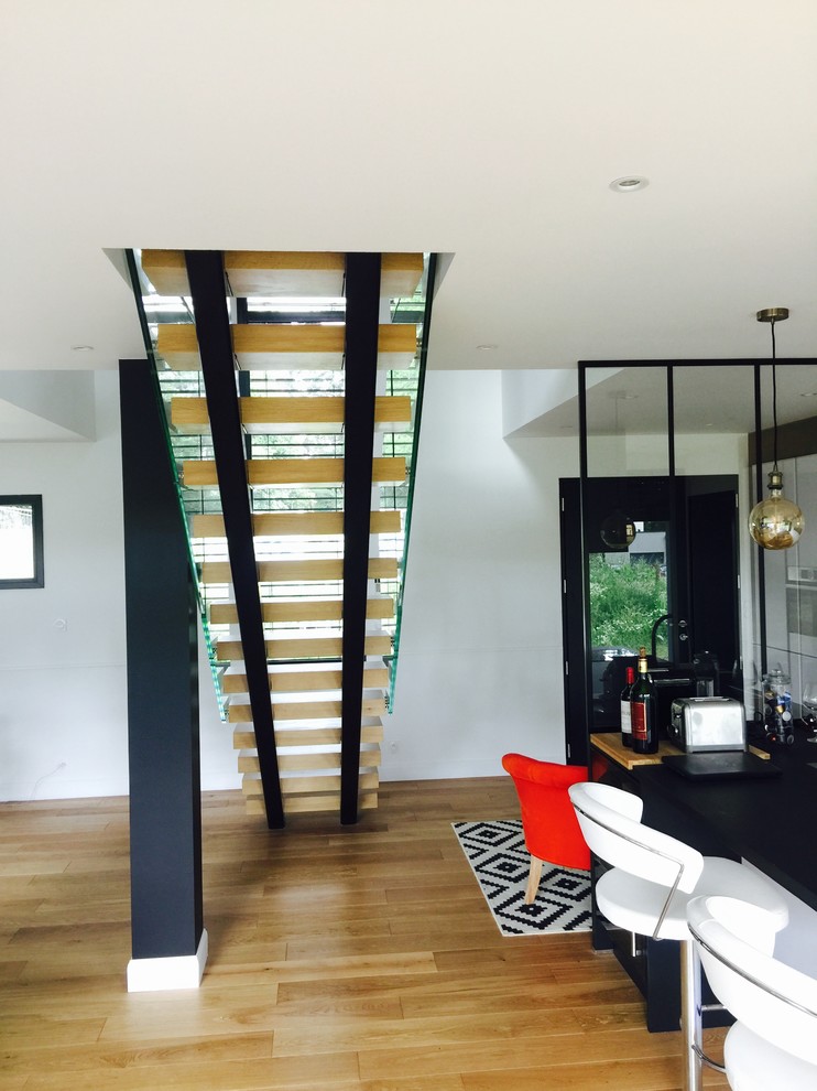 Imagen de escalera recta actual sin contrahuella con escalones de madera y barandilla de vidrio
