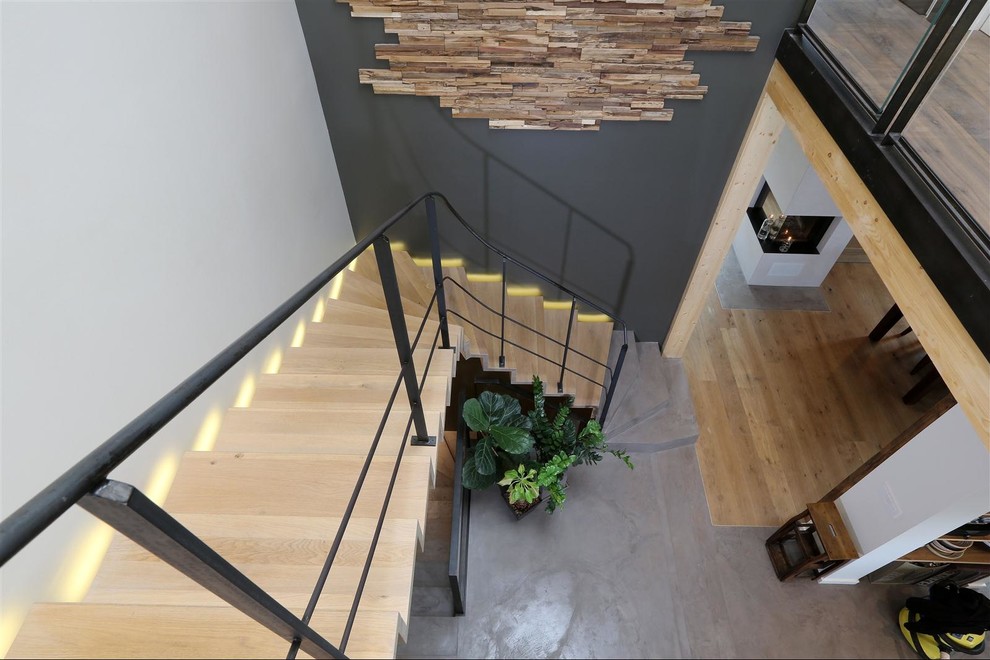 Ejemplo de escalera en L contemporánea grande con contrahuellas de madera y escalones de madera