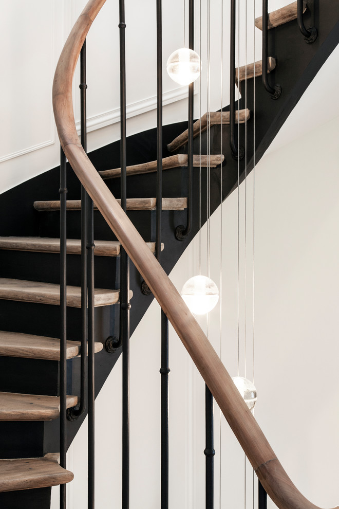 Cette image montre un escalier peint courbe design de taille moyenne avec des marches en bois et un garde-corps en matériaux mixtes.
