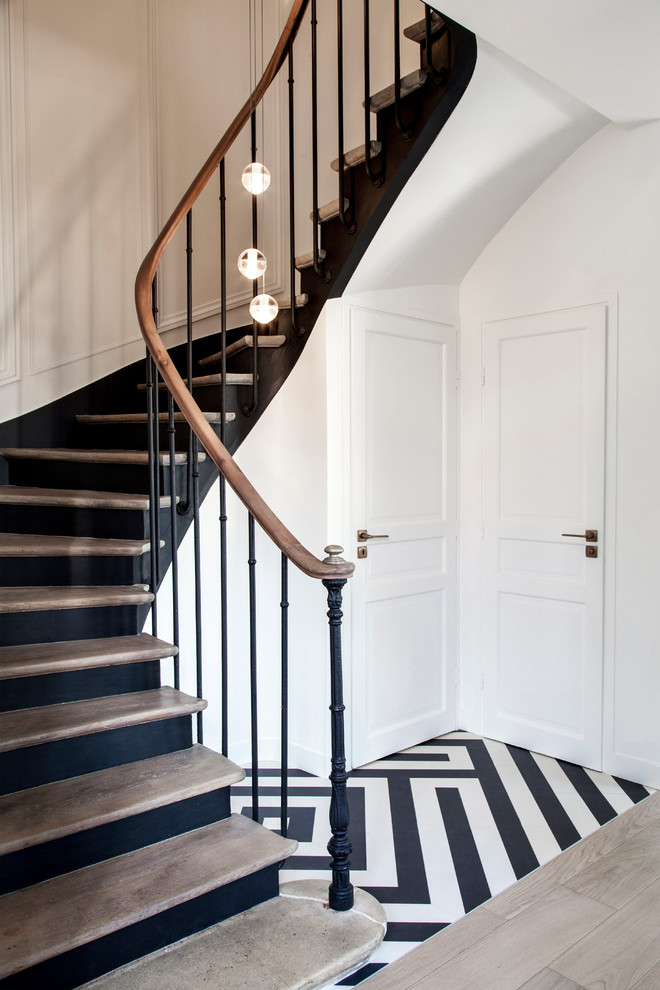 Réalisation d'un escalier peint courbe design de taille moyenne avec des marches en bois et un garde-corps en matériaux mixtes.
