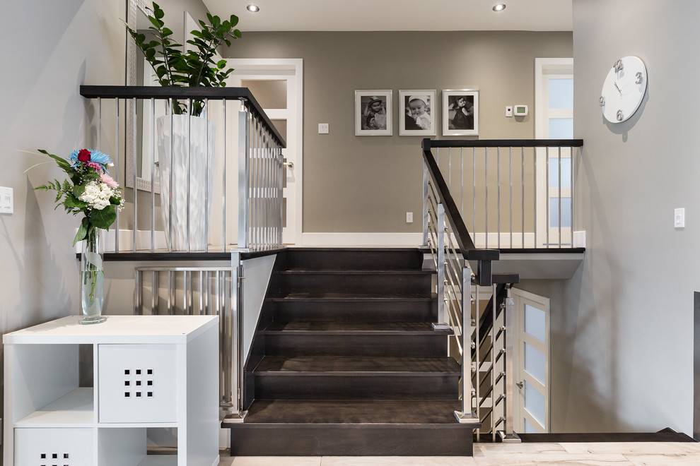 This is an example of a mid-sized contemporary wood straight staircase in Montreal with open risers and metal railing.