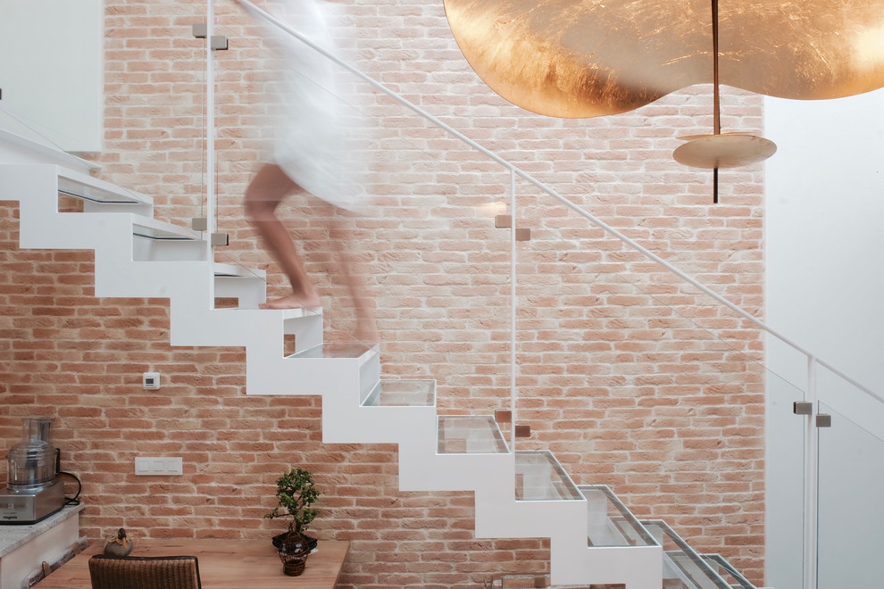 Diseño de escalera suspendida contemporánea de tamaño medio con escalones de vidrio y barandilla de metal