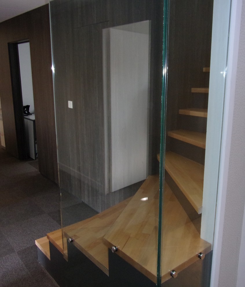 Inspiration pour un escalier design avec des marches en bois, des contremarches en bois et un garde-corps en verre.
