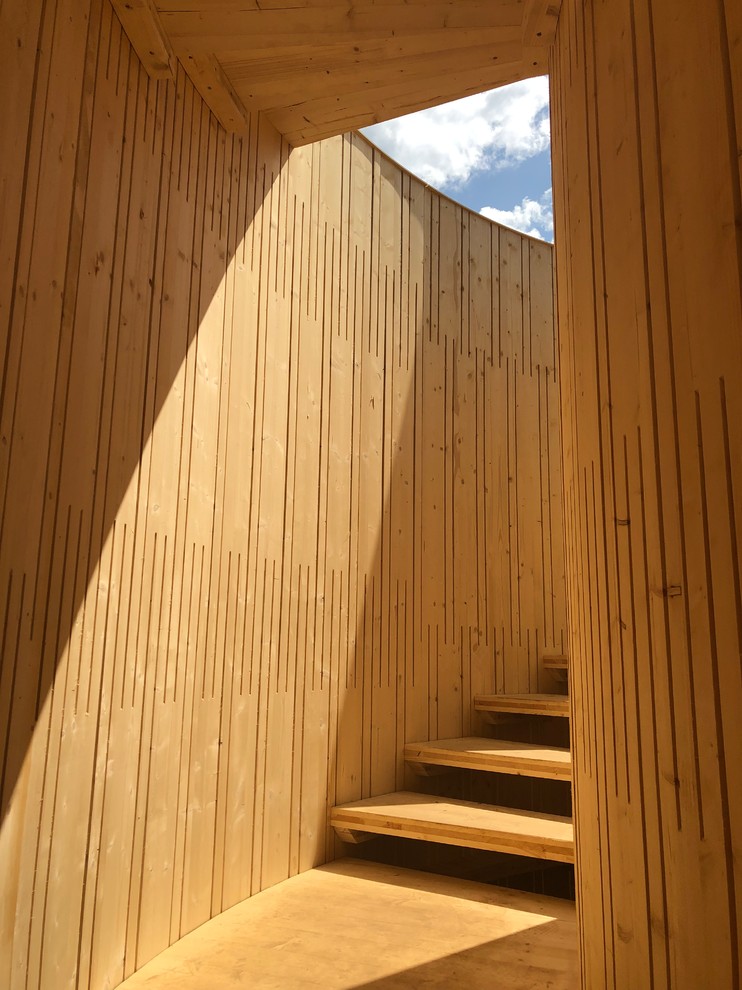 На фото: огромная винтовая лестница в современном стиле с деревянными ступенями и деревянными перилами