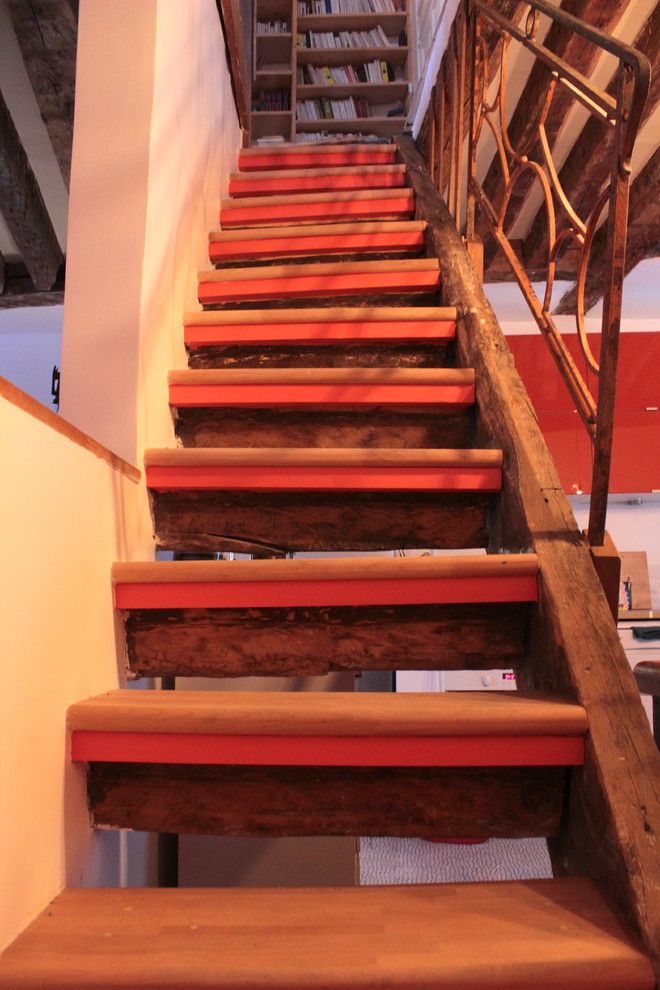 Ejemplo de escalera recta exótica de tamaño medio con escalones de madera, contrahuellas de madera pintada y barandilla de metal