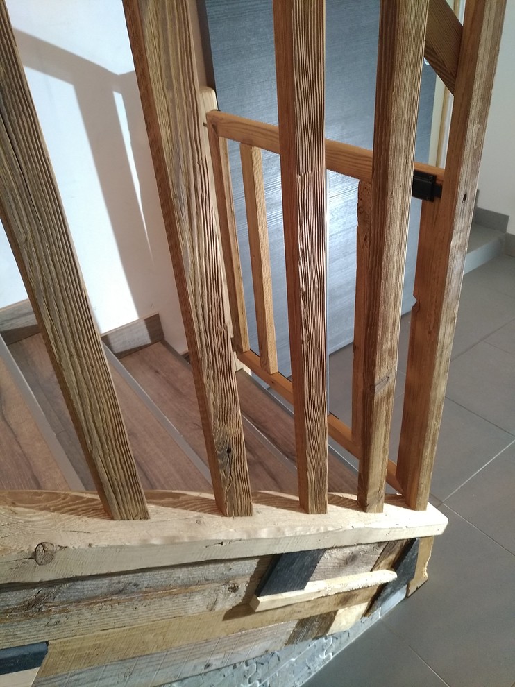 Imagen de escalera en L rural pequeña con escalones de madera, contrahuellas de madera y barandilla de madera