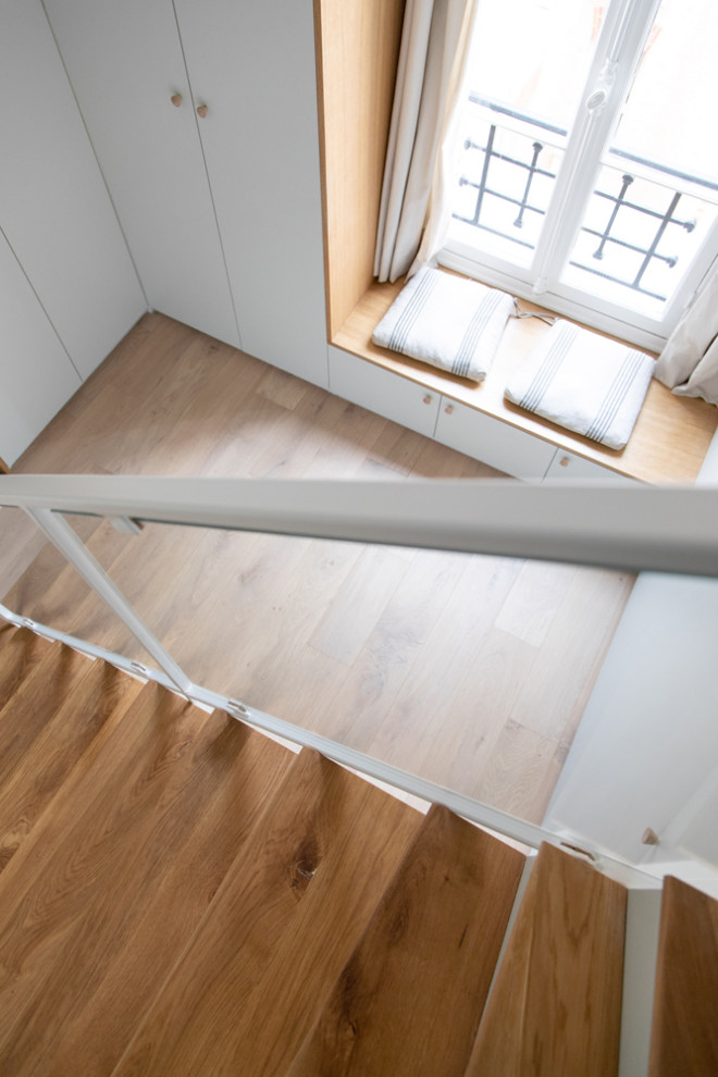 Cette image montre un petit escalier peint courbe traditionnel avec des marches en bois et un garde-corps en matériaux mixtes.