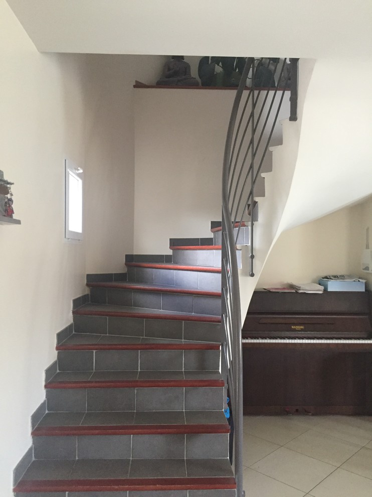 Идея дизайна: п-образная лестница среднего размера в современном стиле с ступенями из плитки, подступенками из плитки и металлическими перилами