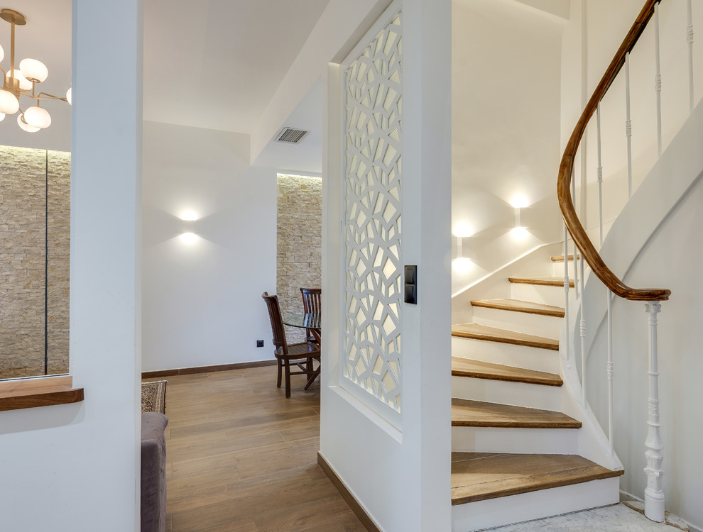 Idées déco pour un escalier courbe contemporain de taille moyenne avec des marches en bois, des contremarches en bois et un garde-corps en bois.