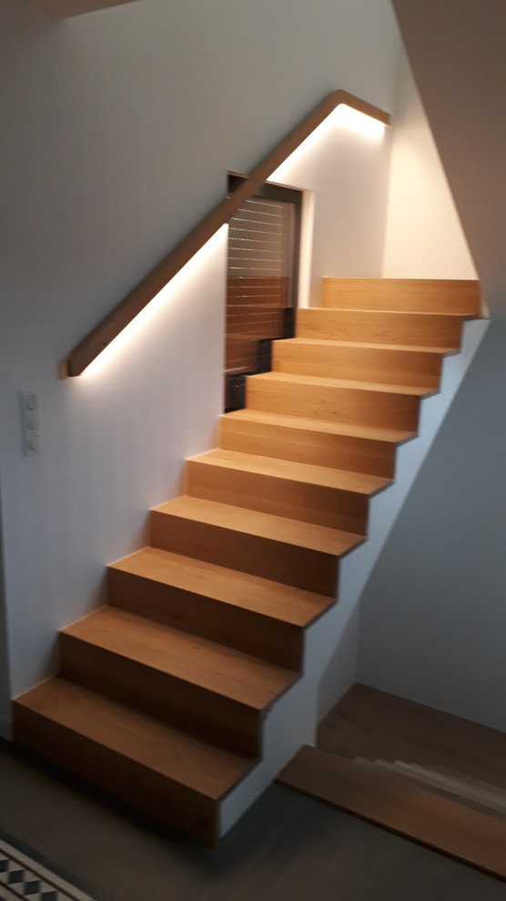 Imagen de escalera en U moderna grande con escalones de madera, contrahuellas de madera y barandilla de madera