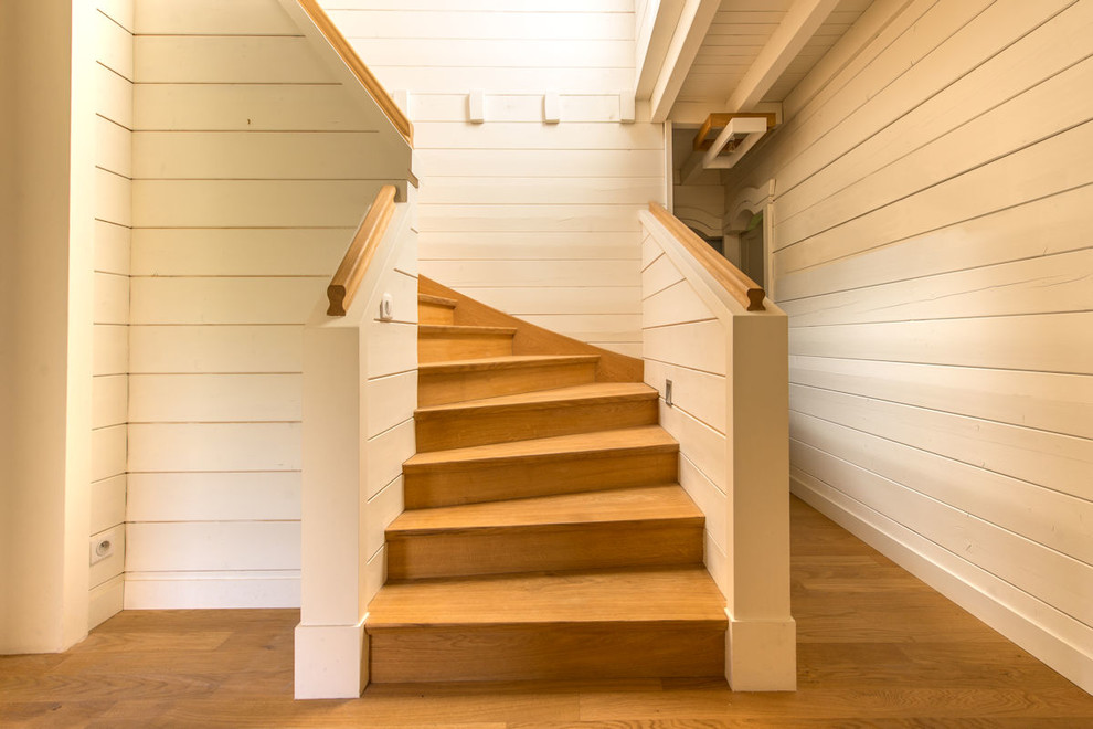Idées déco pour un grand escalier scandinave en U avec des marches en bois, des contremarches en bois et un garde-corps en bois.