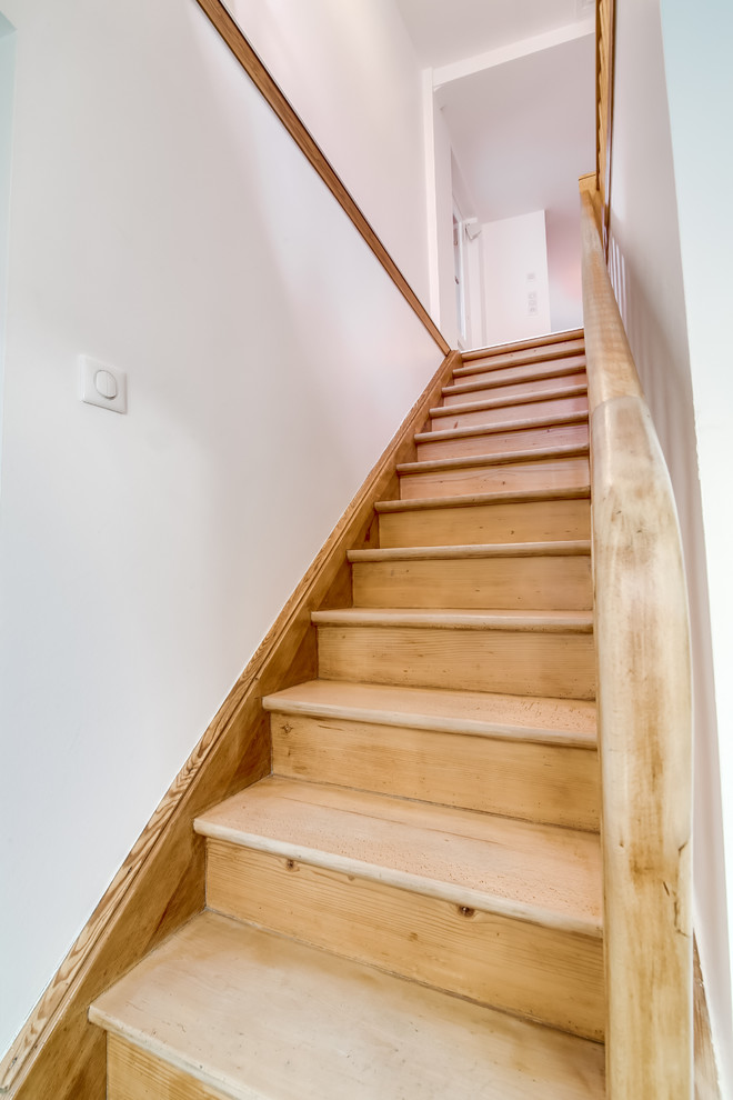 Diseño de escalera recta de estilo de casa de campo pequeña con escalones de madera, contrahuellas de madera y barandilla de madera