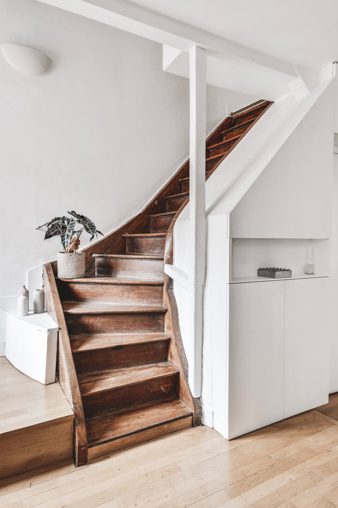 Источник вдохновения для домашнего уюта: изогнутая деревянная лестница среднего размера в современном стиле с деревянными ступенями и кладовкой или шкафом под ней