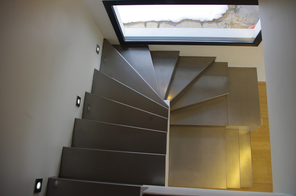 Exemple d'un escalier tendance en L de taille moyenne avec des marches en métal, des contremarches en métal et un garde-corps en verre.