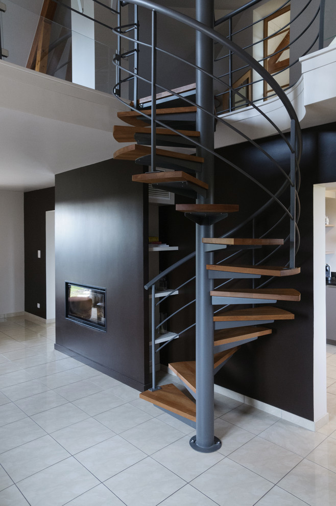 На фото: винтовая лестница среднего размера в современном стиле с деревянными ступенями без подступенок