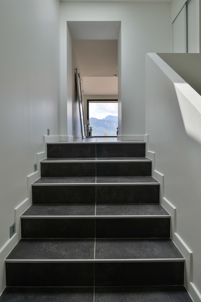 Пример оригинального дизайна: прямая лестница среднего размера в стиле модернизм с ступенями из плитки и подступенками из плитки
