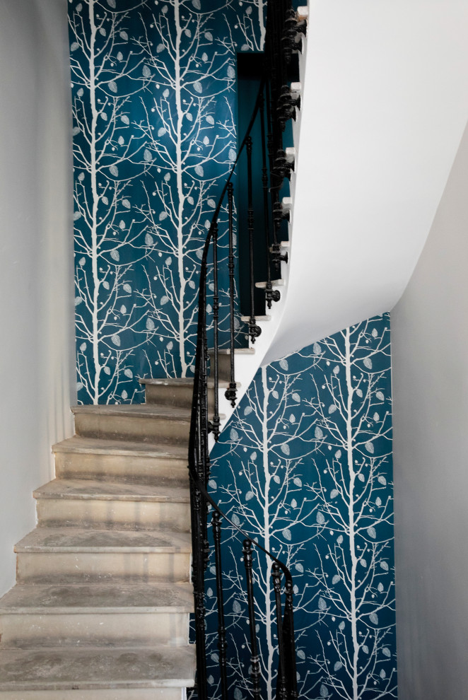 На фото: лестница в стиле лофт с металлическими перилами и обоями на стенах с