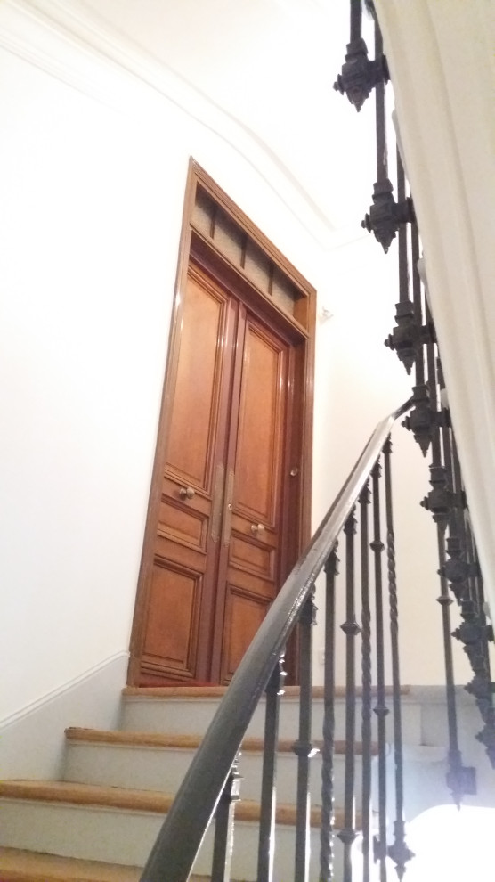 Imagen de escalera de caracol clásica renovada de tamaño medio con escalones de madera, contrahuellas de madera pintada y barandilla de metal