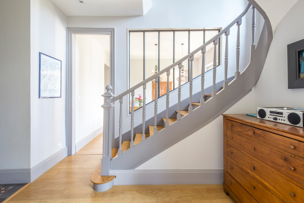 Imagen de escalera curva tradicional renovada de tamaño medio con escalones de madera, contrahuellas de madera y barandilla de madera