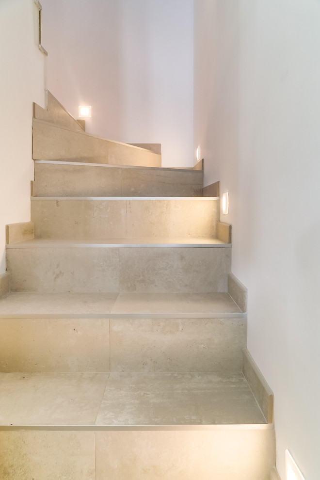 Idée de décoration pour un escalier design en L de taille moyenne avec des marches en pierre calcaire et des contremarches en pierre calcaire.