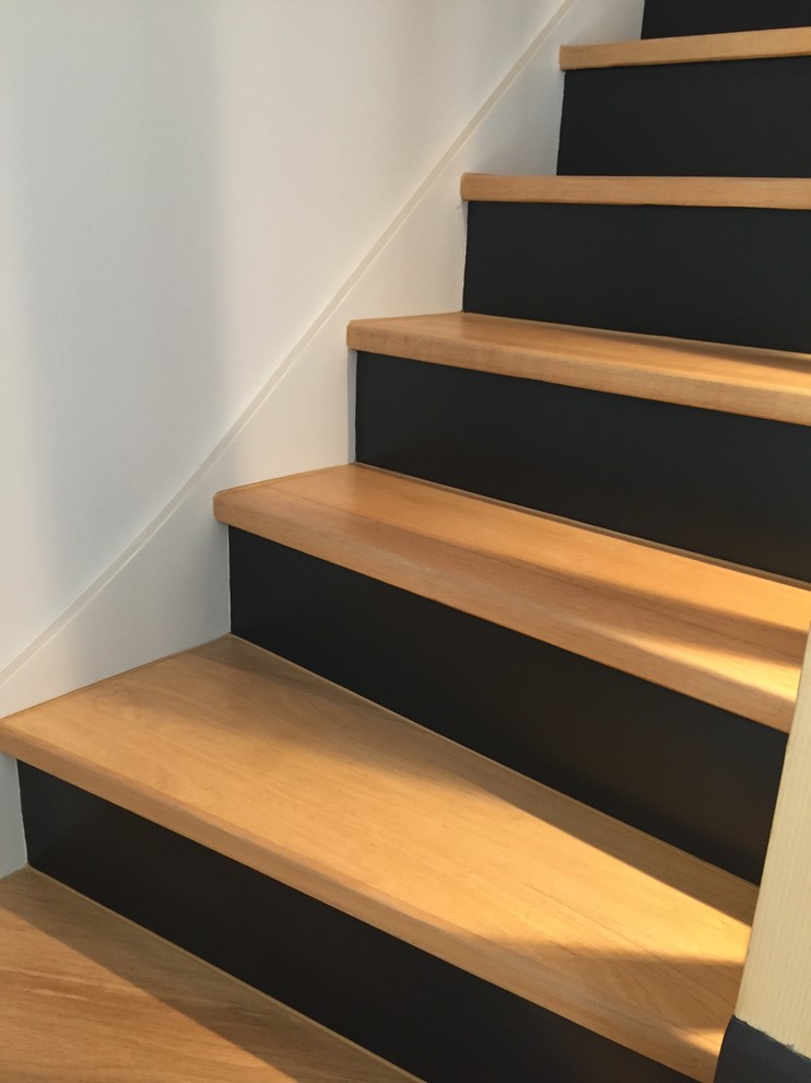 Idées déco pour un escalier peint contemporain en L de taille moyenne avec des marches en bois et un garde-corps en bois.