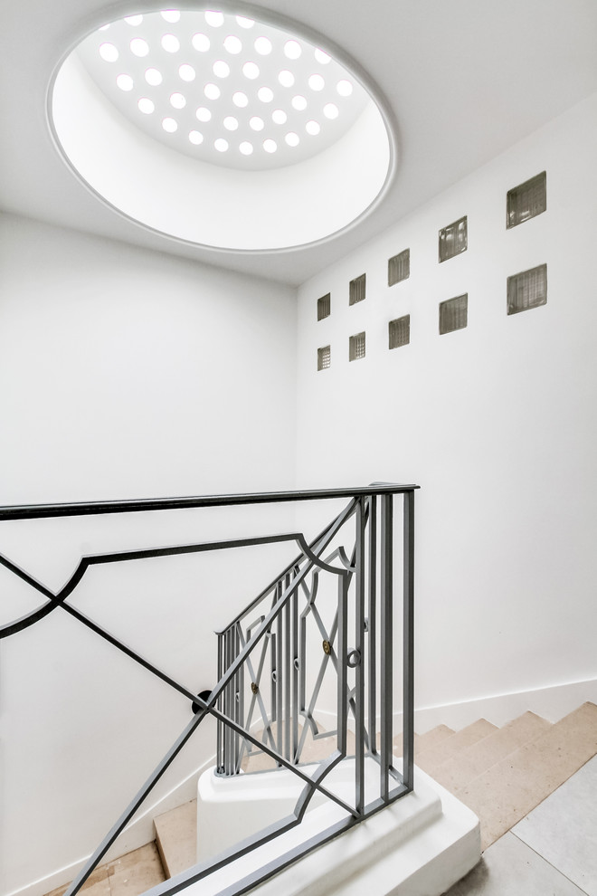 Modelo de escalera curva clásica renovada grande con escalones de mármol, contrahuellas de mármol y barandilla de metal