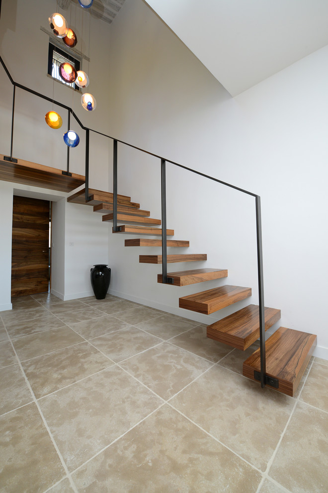 Diseño de escalera curva actual pequeña con escalones de madera y barandilla de metal