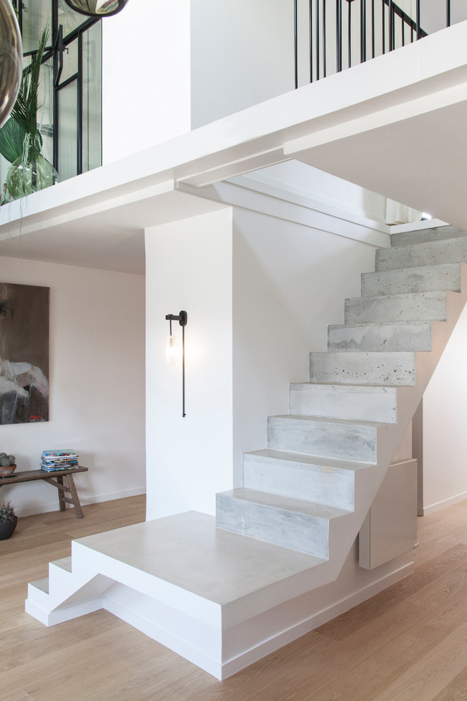Идея дизайна: угловая бетонная лестница среднего размера в современном стиле с бетонными ступенями и металлическими перилами