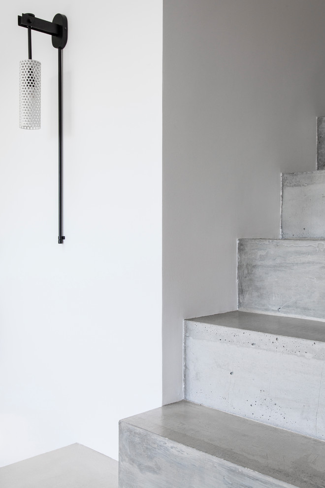Modern inredning av en mellanstor trappa, med sättsteg i betong och räcke i metall