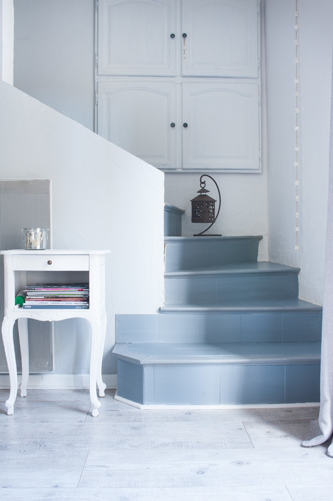 Exemple d'un escalier carrelé courbe romantique de taille moyenne avec des contremarches carrelées.