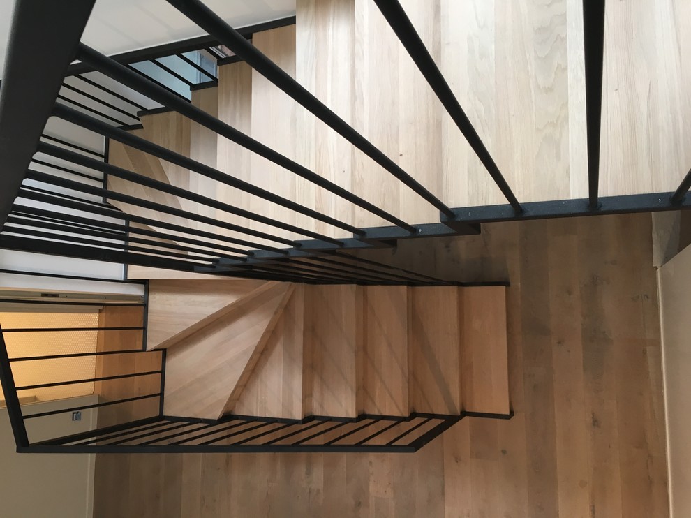 Inspiration for a mid-sized wooden u-shaped staircase remodel in Paris with wooden risers