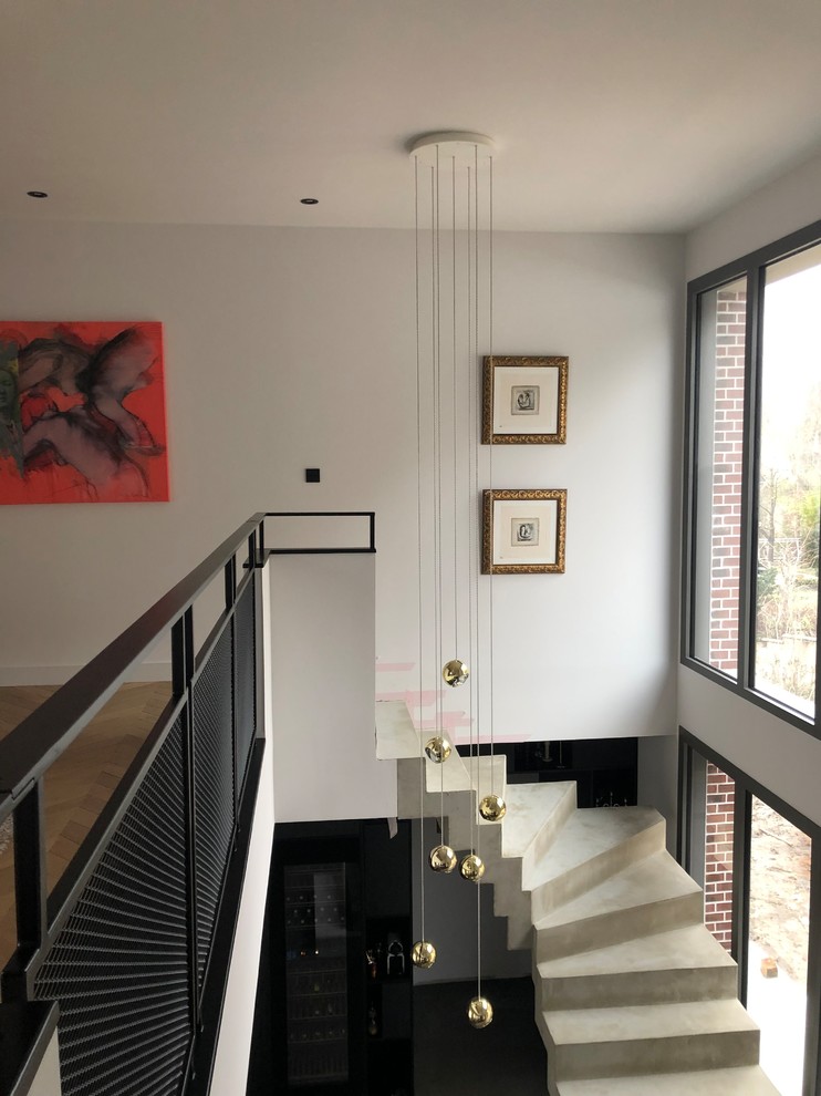 Свежая идея для дизайна: винтовая бетонная лестница среднего размера в стиле фьюжн с бетонными ступенями и металлическими перилами - отличное фото интерьера