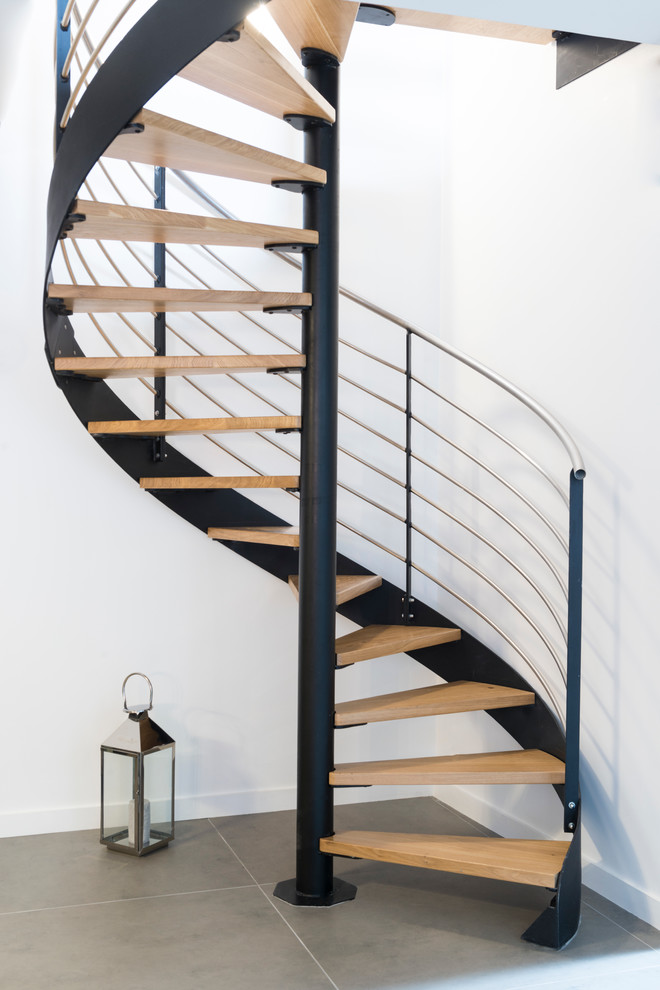 Свежая идея для дизайна: большая винтовая лестница в современном стиле с деревянными ступенями - отличное фото интерьера