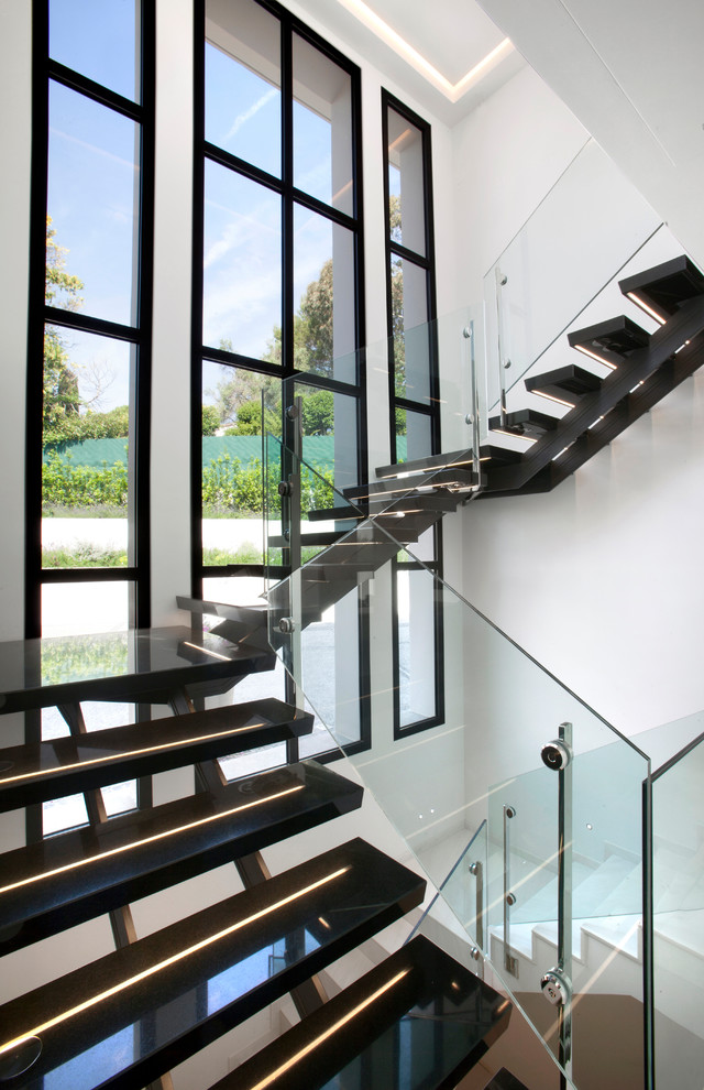 Exempel på en modern u-trappa, med öppna sättsteg och räcke i glas