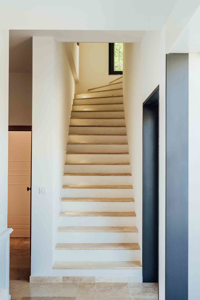 Idée de décoration pour un grand escalier carrelé méditerranéen en L.