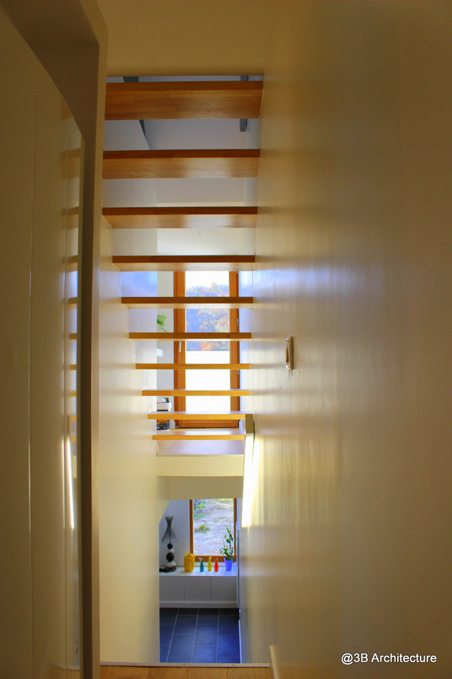 Cette image montre un petit escalier droit minimaliste avec des marches en bois.