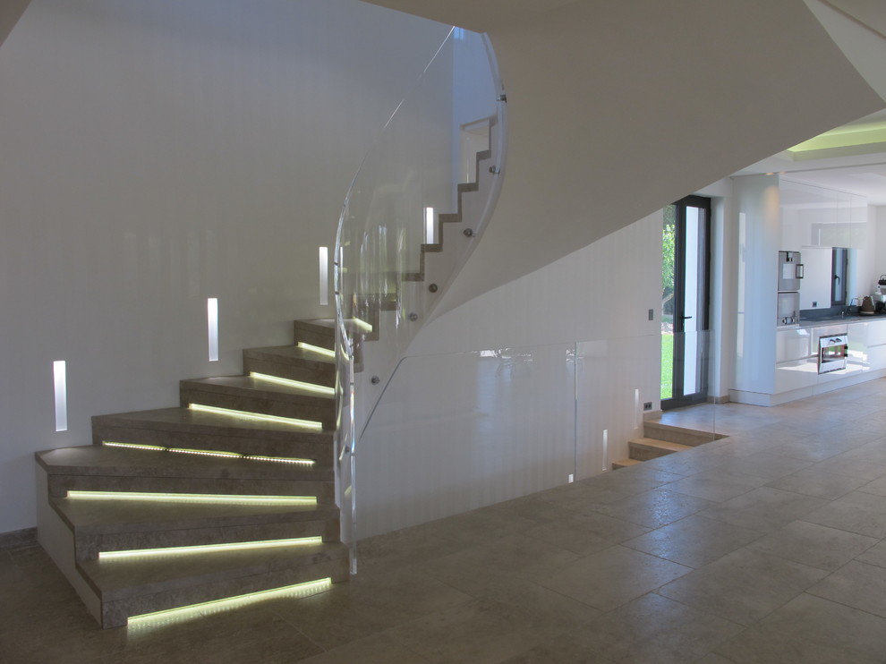 Cette image montre un grand escalier carrelé courbe design avec des contremarches carrelées.