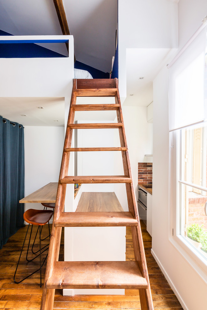 パリにある高級な小さなインダストリアルスタイルのおしゃれな直階段 (木の蹴込み板、木材の手すり) の写真