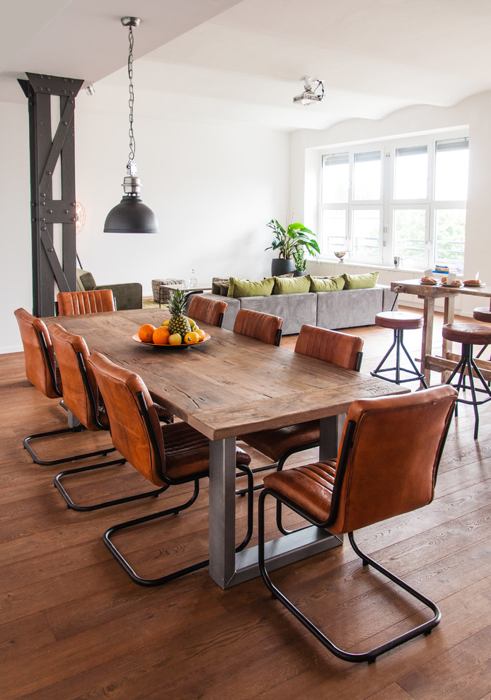 Esempio di una sala da pranzo aperta verso il soggiorno industriale di medie dimensioni con pareti bianche e pavimento in legno massello medio