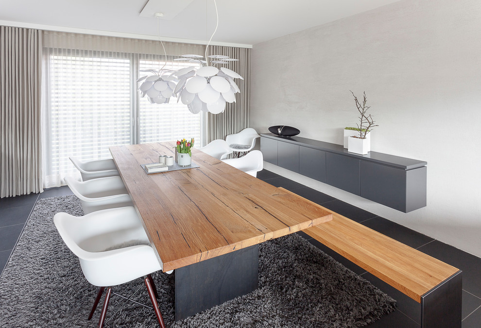 Foto di una sala da pranzo aperta verso il soggiorno design di medie dimensioni con pareti grigie, pavimento con piastrelle in ceramica e pavimento nero