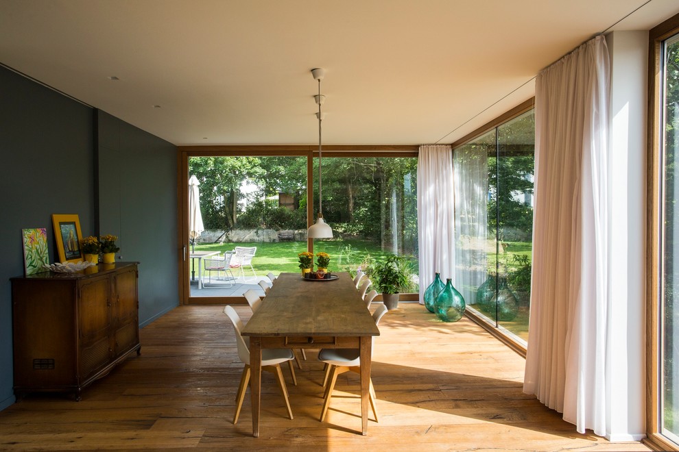 Idee per una sala da pranzo minimal con pareti grigie e pavimento in legno massello medio