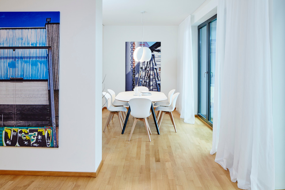 Offenes, Kleines Modernes Esszimmer ohne Kamin mit weißer Wandfarbe und hellem Holzboden in Hamburg