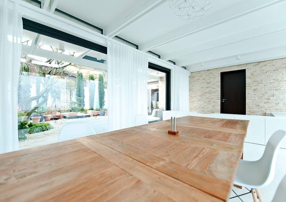 Inspiration for a large contemporary open plan dining room in Munich with white walls, porcelain flooring, a standard fireplace and a tiled fireplace surround.
