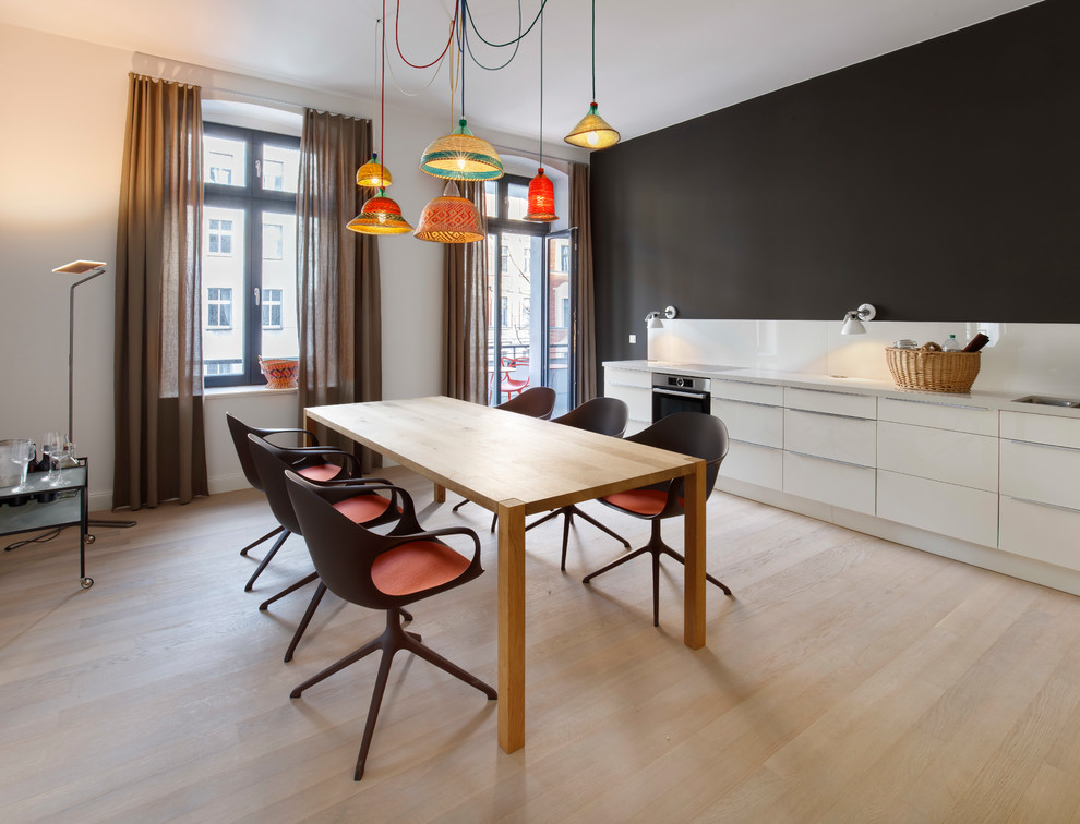 Große Moderne Wohnküche ohne Kamin mit hellem Holzboden, weißer Wandfarbe und beigem Boden in Berlin