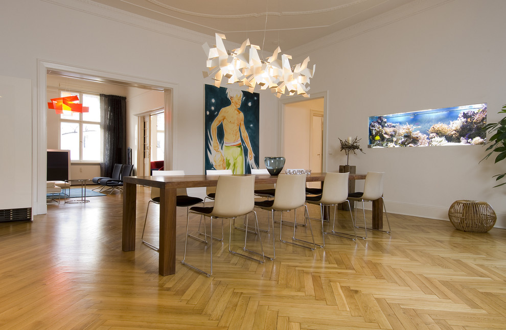 Contemporary open plan dining room in Berlin with white walls and light hardwood flooring.