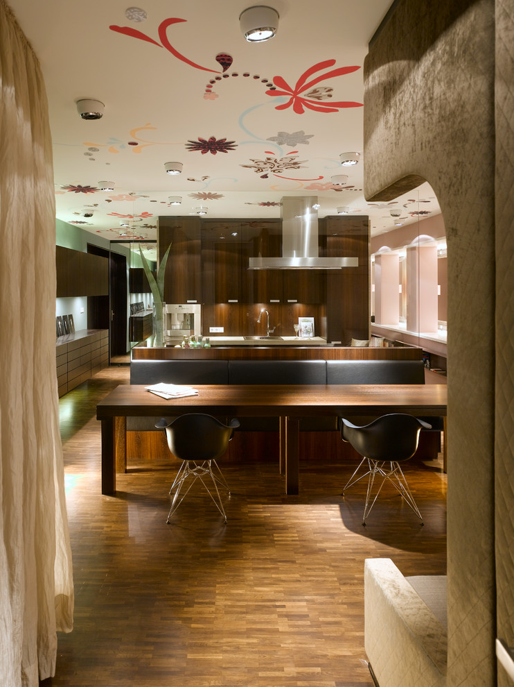 Modelo de comedor contemporáneo con paredes multicolor y suelo de madera en tonos medios